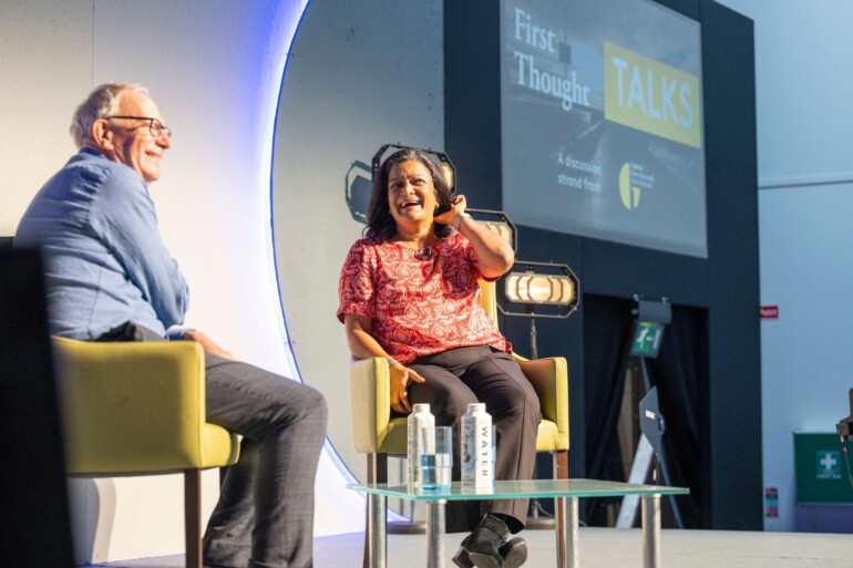 Two speakers sitting and talking on stage