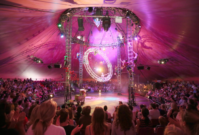 Acrobats performing in a circus tent